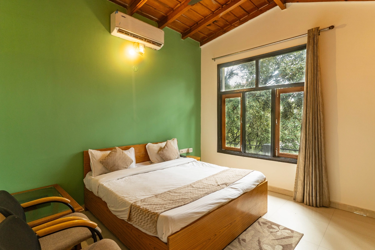 Bright Maya Regency room with a double bed and green walls